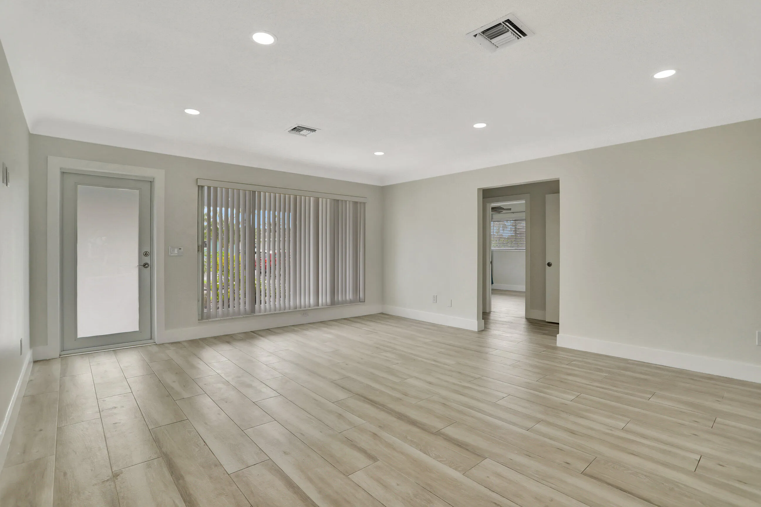 Facing the front door and large picture windows. Door on the right leads to the bedrooms.