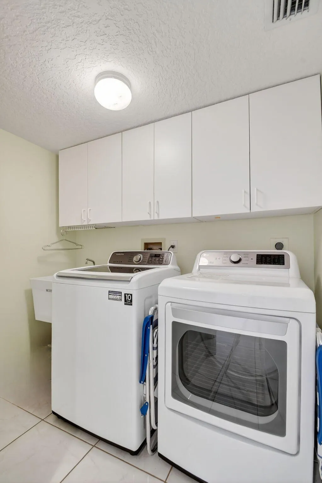 Laundry room with sink and additional cabinets.