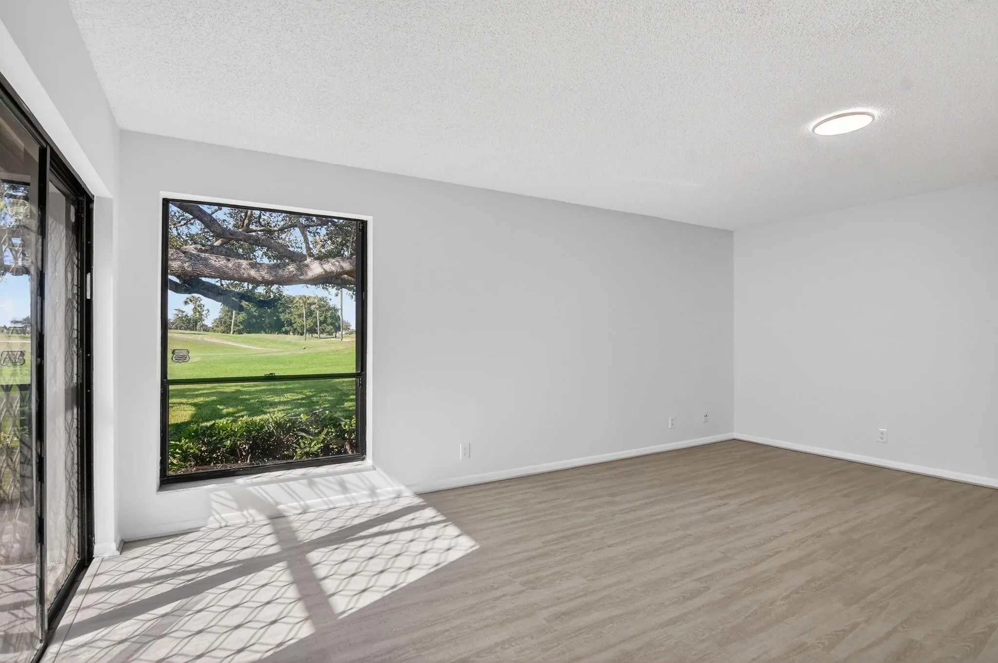Bright corner primary bedroom features luxury vinyl plank flooring.