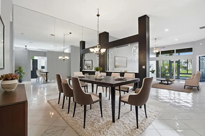 Spacious dining area with soaring ceilings and an open layout that flows effortlessly into the main living spaces. The mirrored accent wall enhances the sense of space and light while the elegant chandelier creates an ideal setting for both everyday dining and entertaining.
