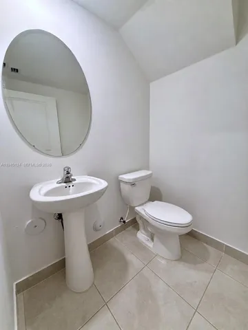 Stylish powder room with modern fixtures and a clean, minimalist design, perfect for guests.