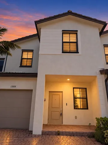 Welcome home to 13108 SW 232nd Ln — a 2022 Lennar townhome in gated Siena Reserve. Twilight lighting digitally enhanced.