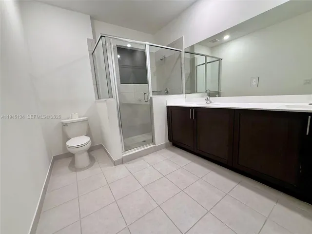 Another view of the primary bathroom showcasing a glass-enclosed shower and modern finishes.