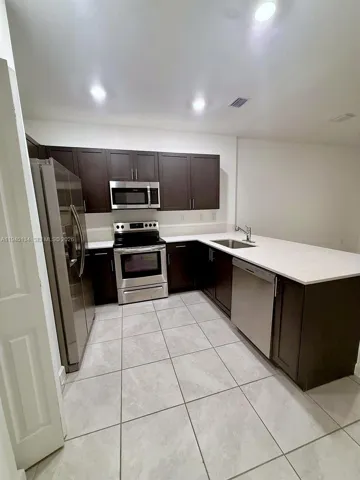 Modern kitchen with contemporary cabinetry, sleek countertops, and stainless steel appliances—designed for both function and style.