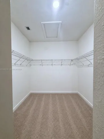 Spacious primary walk-in closet providing ample storage and organization space.