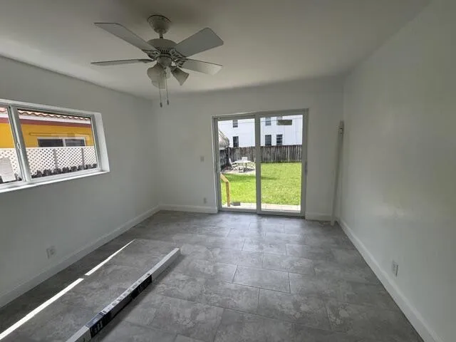 bedroom 1 with large closets and sliding hurricane impact door to back yard