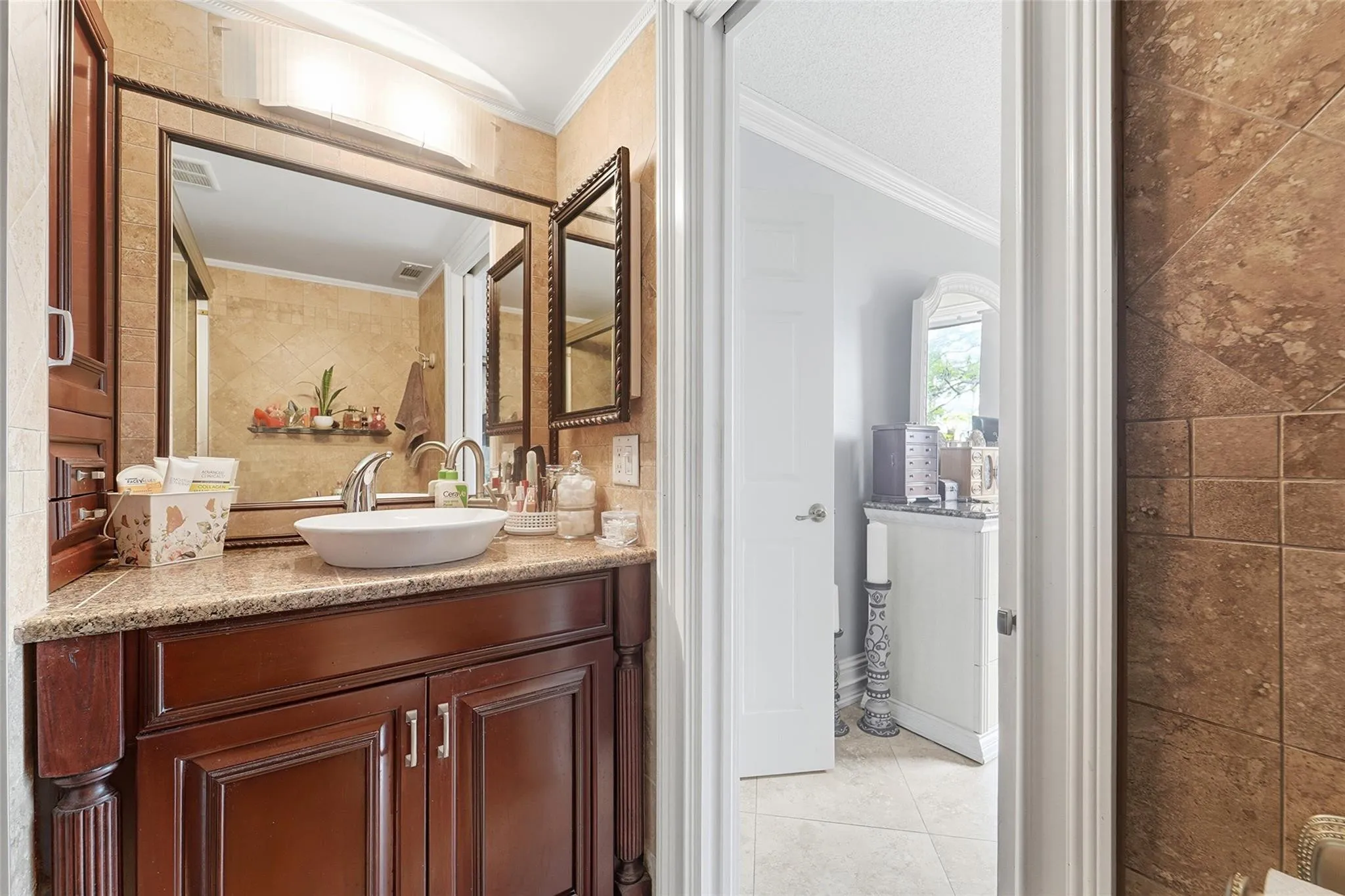 Master bath has a bowl sink and same cabinetry as the kitchen.