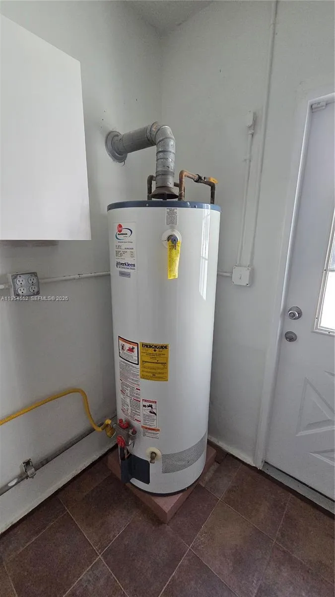 Utility Room with gas dryer and hot water, washer, and utility sink.
