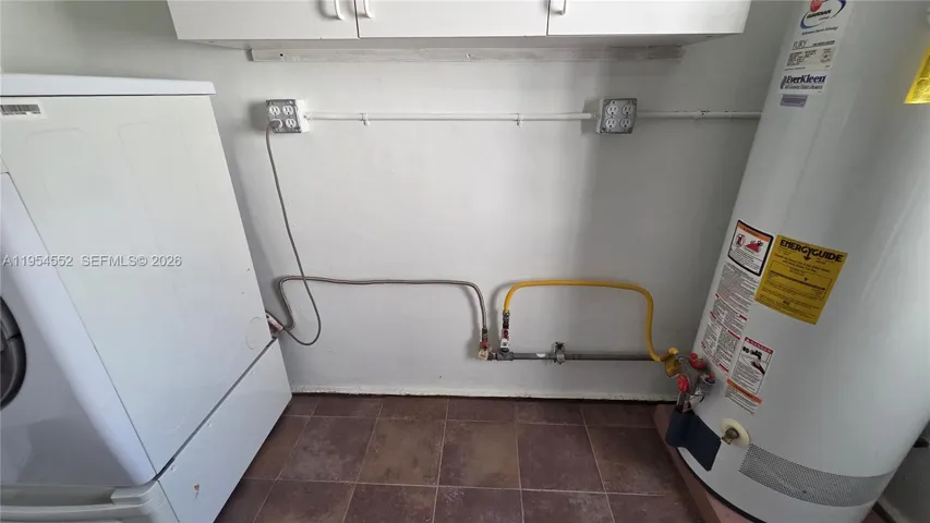 Utility Room with gas dryer and hot water, washer, and utility sink.