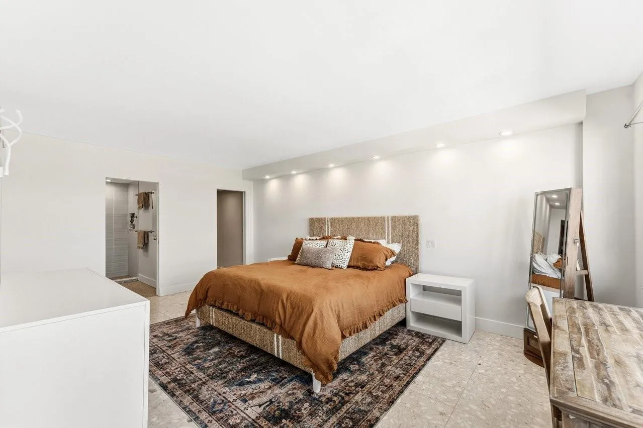 Expansive primary bedroom with ensuite bathroom and walk in closet with custom built-ins