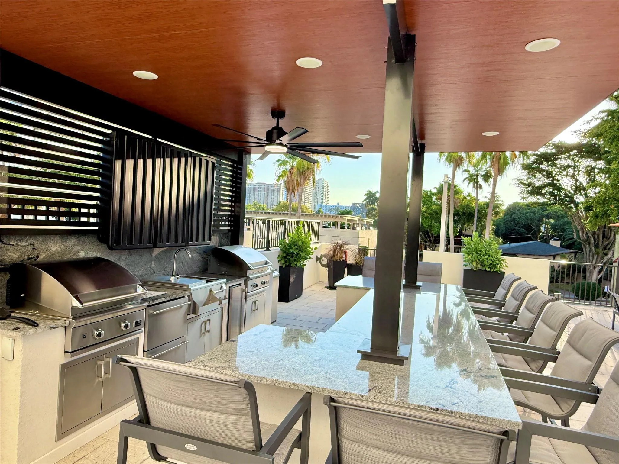 Pergola with a TV, two commercial grills, ice maker, cold storage drawers and cutting station