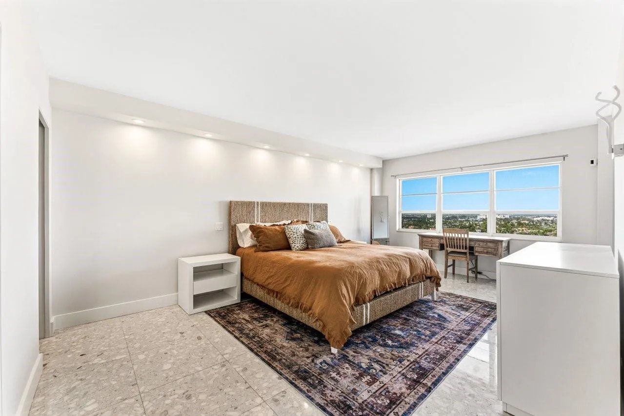 Expansive primary bedroom with water and downtown views
