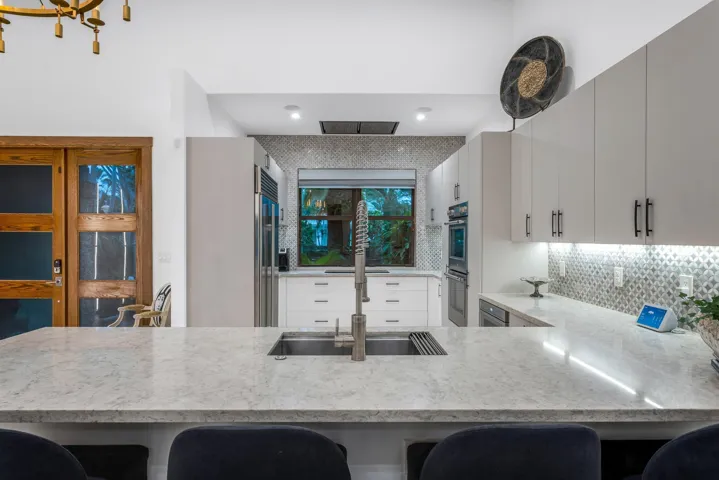 Chef’s kitchen with peninsula seating and tranquil courtyard views.