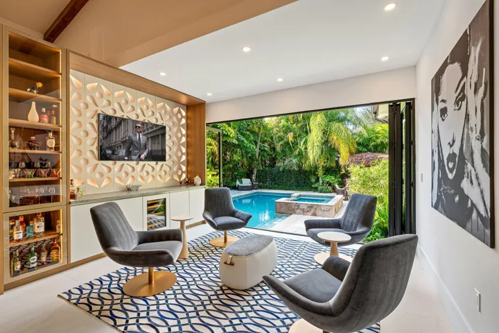 Designer entertaining space with bar, pool views, and lush privacy.