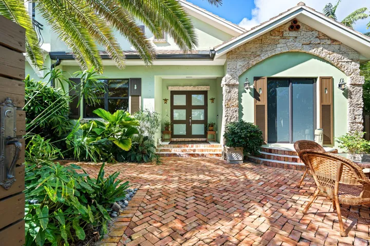 Sun-filled courtyard with lush landscaping and charming brick pavers.
