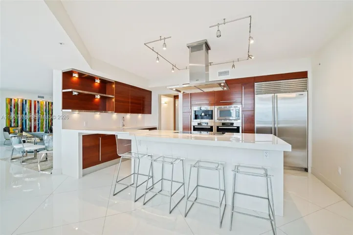 Modern open kitchen with large center island, custom cabinetry, and premium appliances.