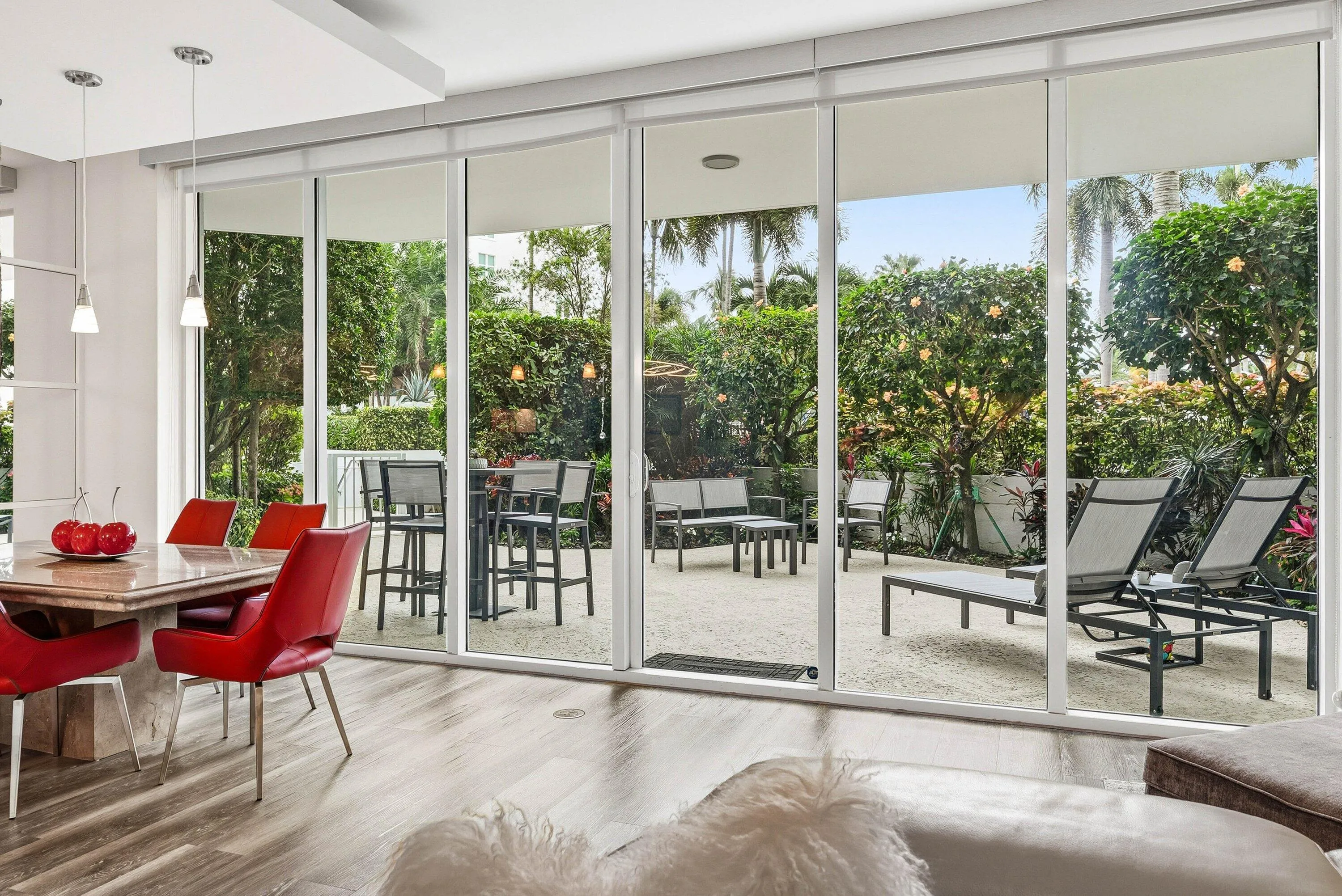 Floor-to-ceiling impact-resistant sliding glass doors lead to your private garden