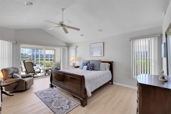 Bedroom with access to outside, new light wood-look LVP flooring in all bedrooms, multiple windows, and ceiling fan