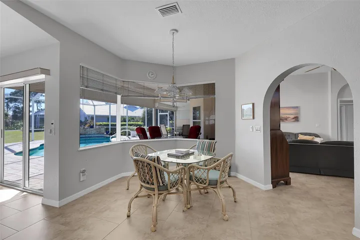 Dining area with bay window, fabulous view of the morning golfers, suspended lighting, and textured ceilings and walls throughout