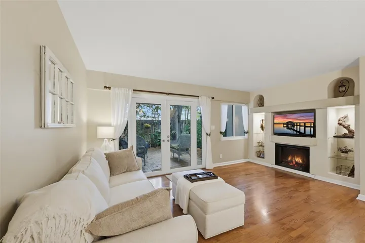 Natural light fills the living room through impact sliding glass doors that open to your own private outdoor retreat.