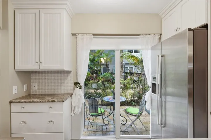 Impact sliding glass doors fill the kitchen with natural light while providing access to the inviting front patio.