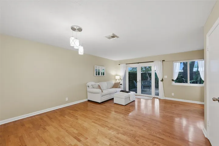 The inviting living room blends indoor comfort with easy access to the private backyard through impact sliding glass doors.