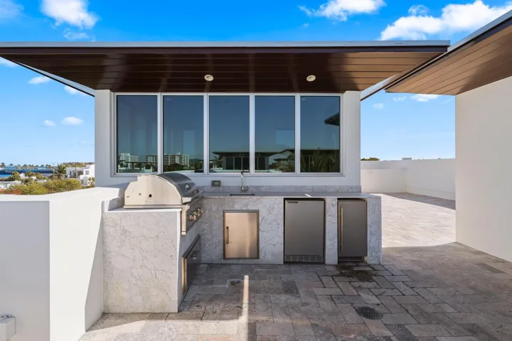 Full summer kitchen with natural gas grill, small fridge and ice maker