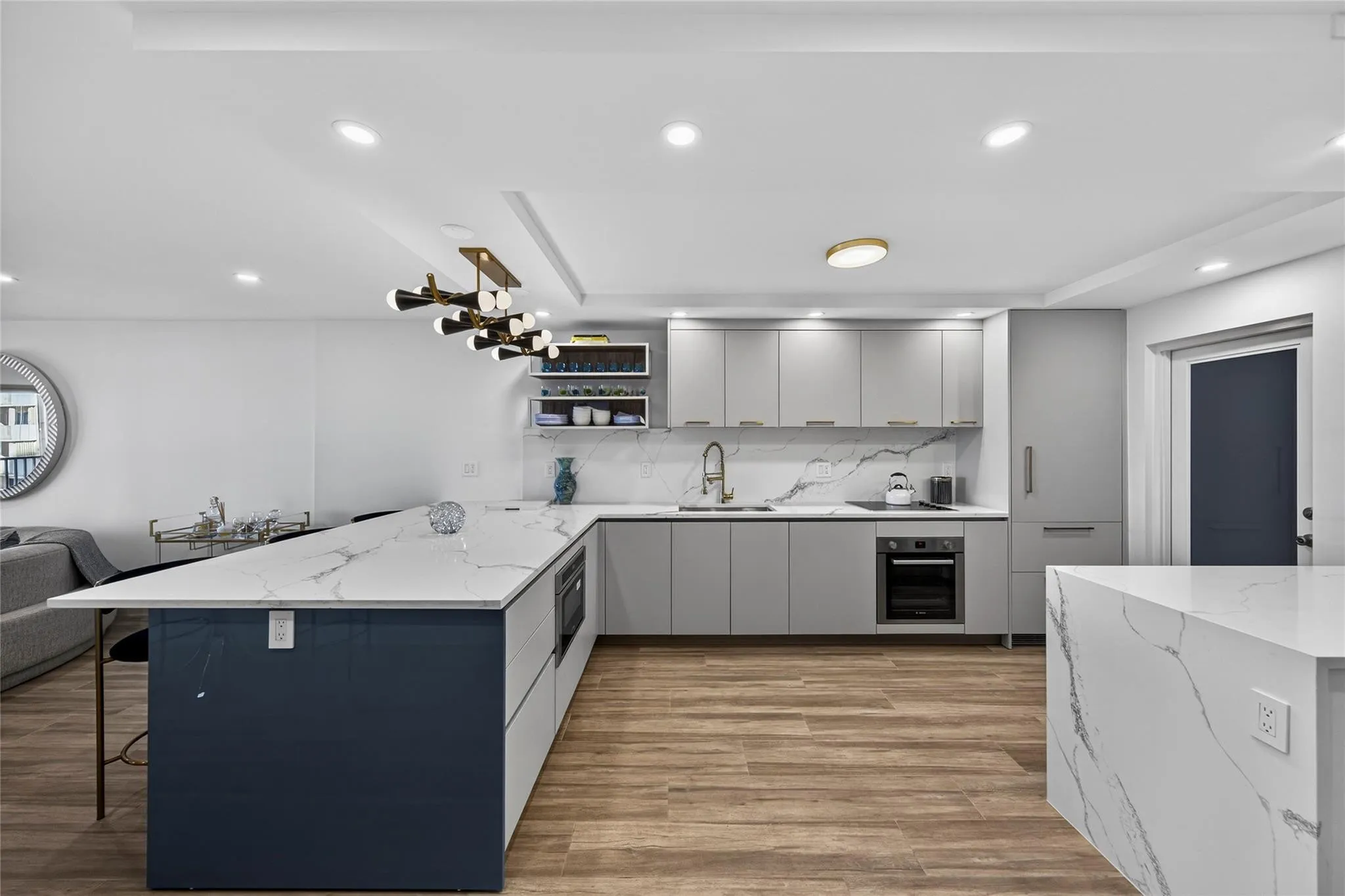 Kitchen with custom Italian cabinets, quartz countertops and high end European appliances. Counter has seating for several people.
