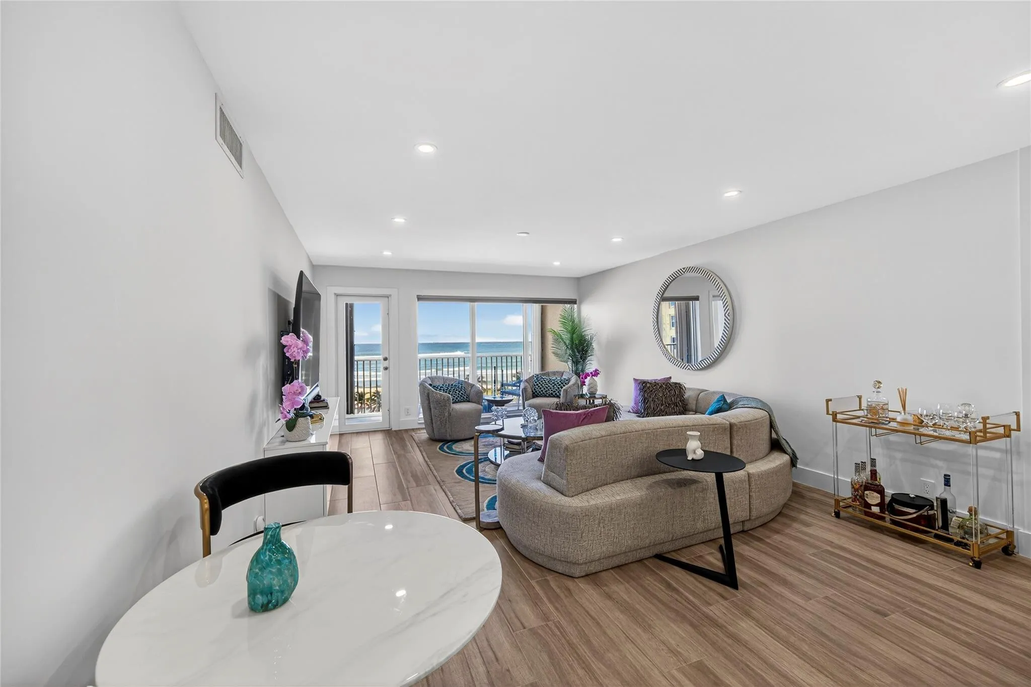 Living, dining and bar with balcony and ocean in the background