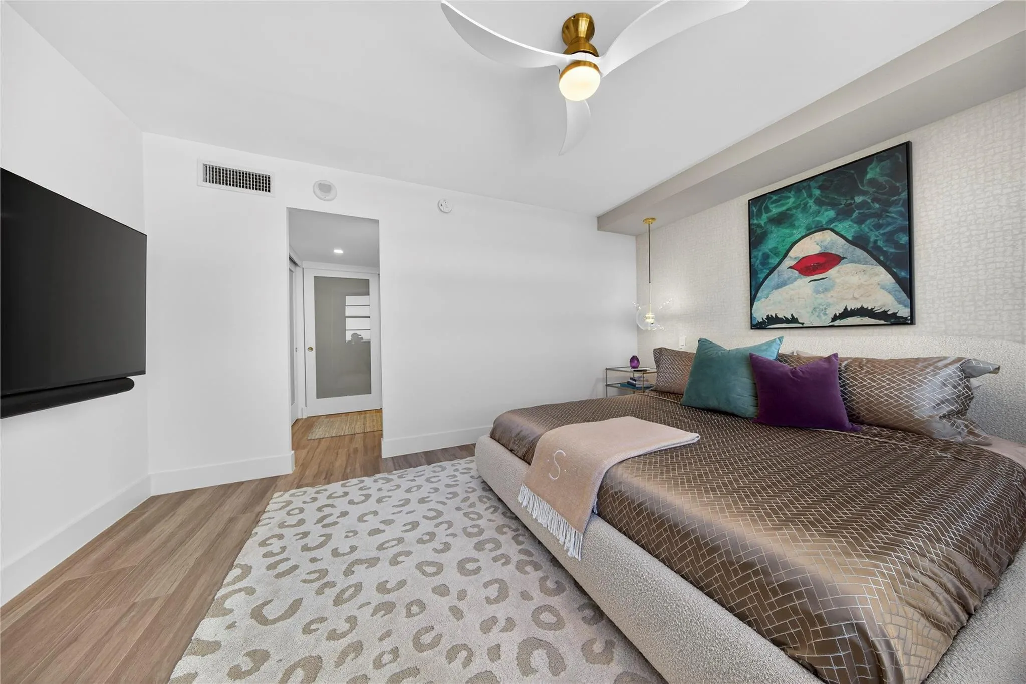 Spacious primary bedroom with a view into closets and dressing area
