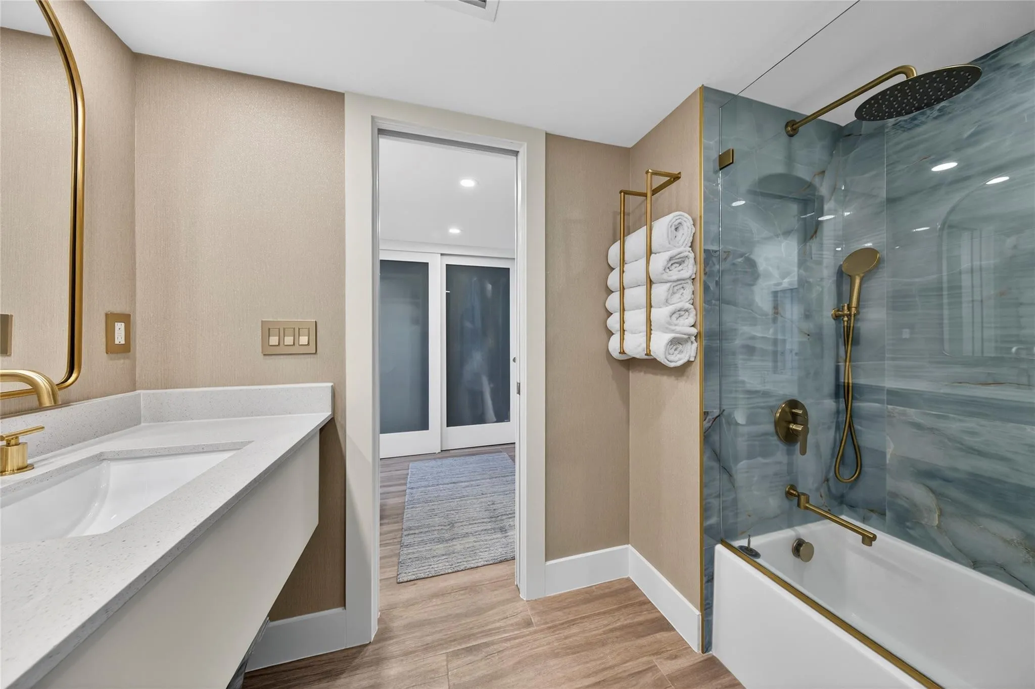Primary ensuite bath with a view into the dressing area and closets