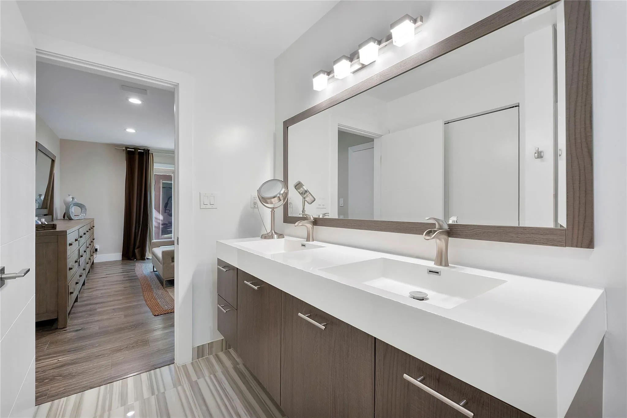 Double vanities and stylish modern wooden cabinets with matching wooden framed mirror & chrome hardware, Porcelain tile flooring in the bathroom and waterproof premium lamintae is all bedrooms and living areas,