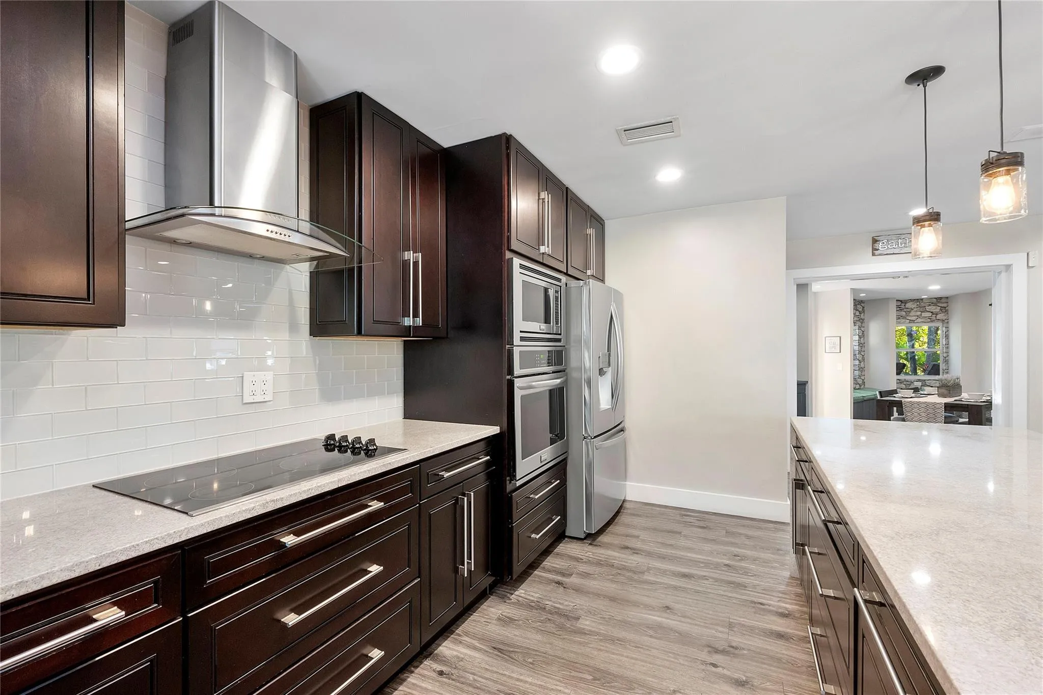 Walnut cabinets & pendant lighting, Stainless steel appliances & granite countertops in the main kitchen,