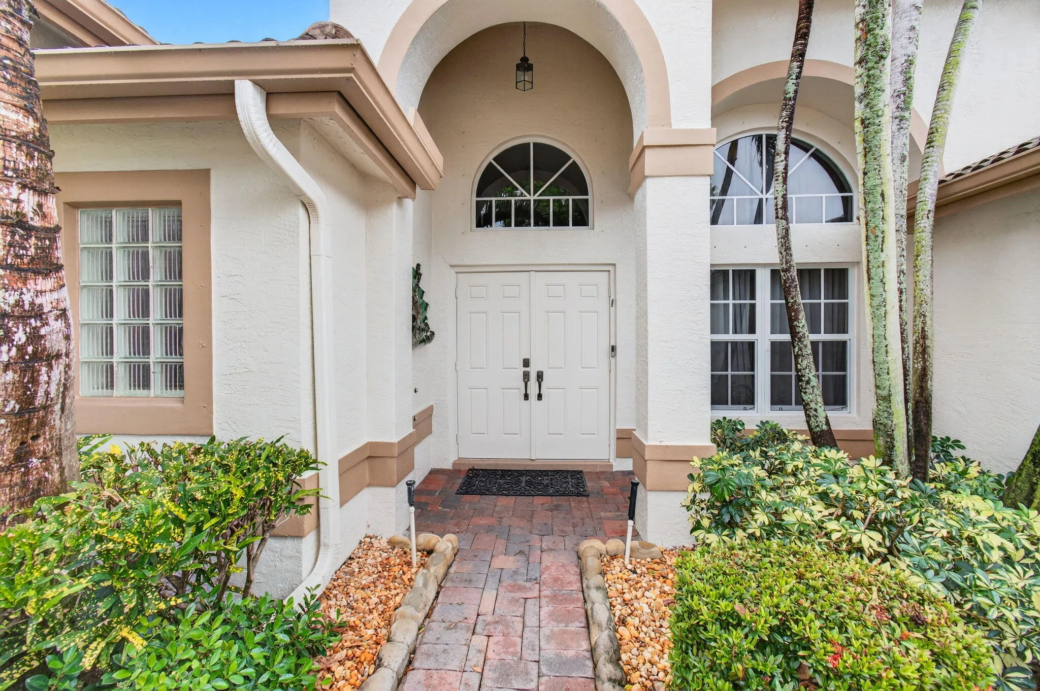 The Mediterranean-style home has an arched entry for protection from rain