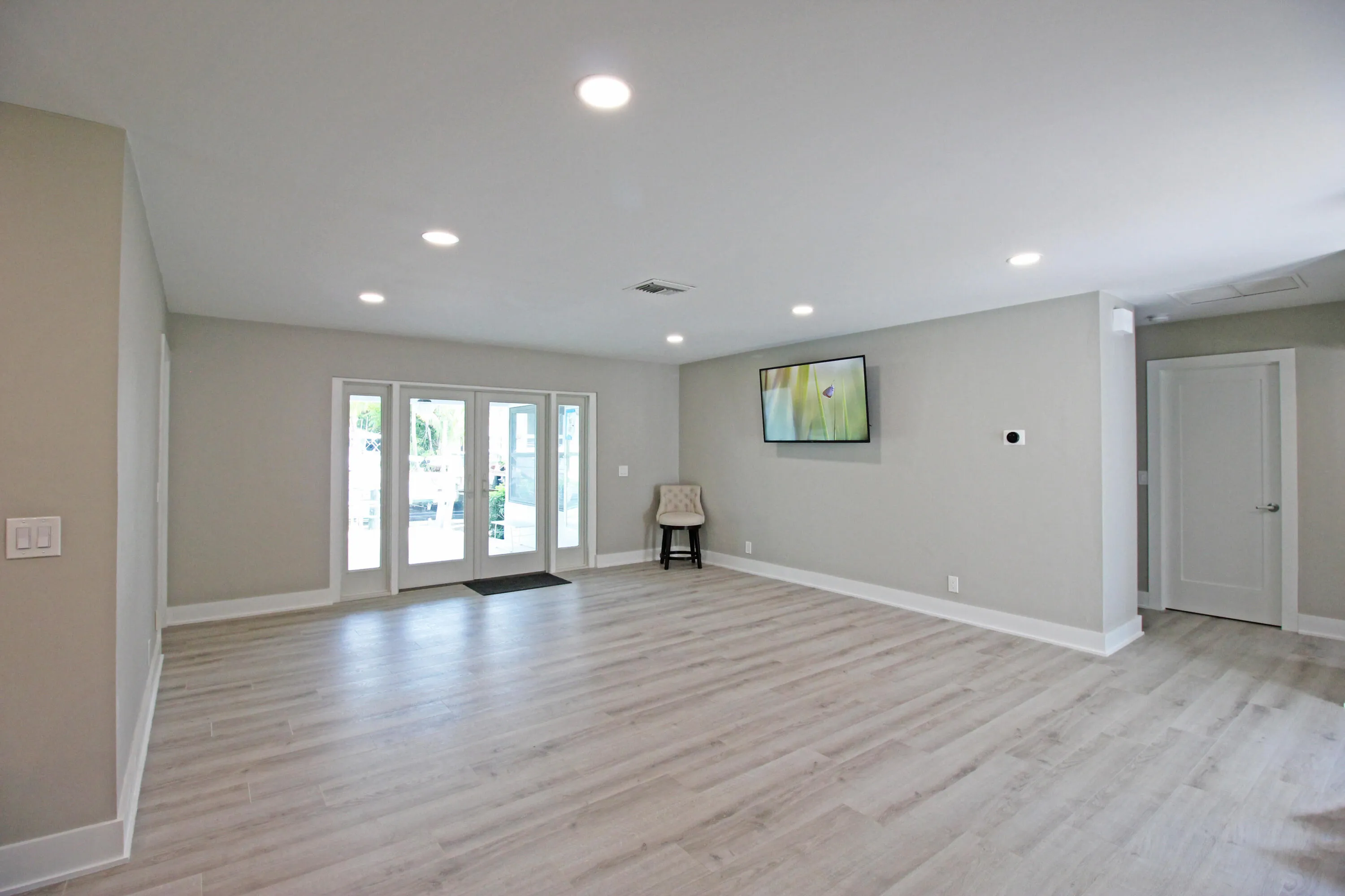French doors open to the patio, pool and dock