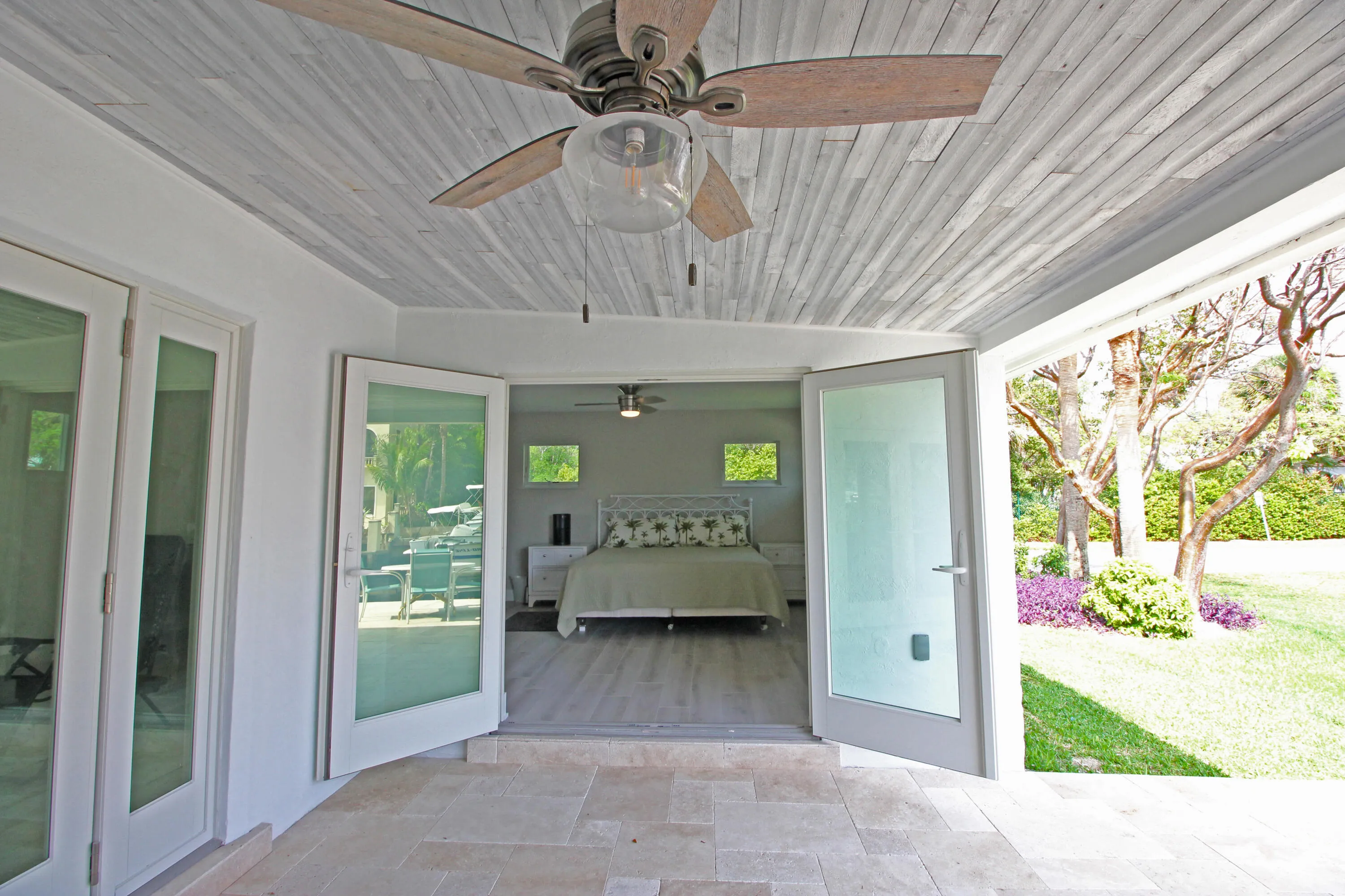 The Master Suite opens to the custom travertine patio, pool and dock