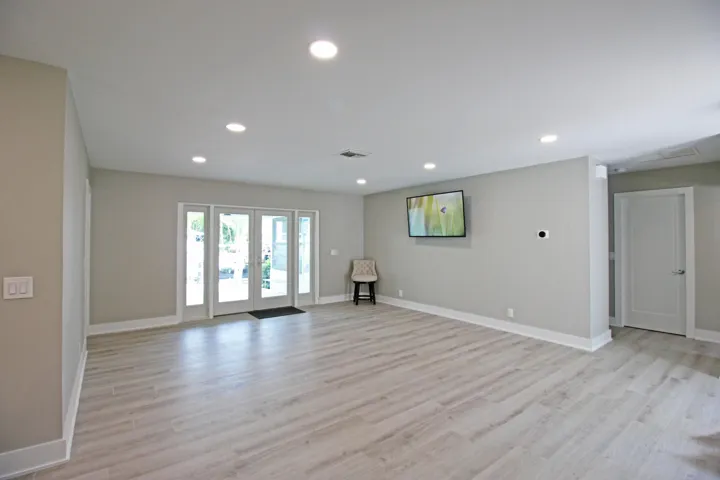 French doors open to the patio, pool and dock