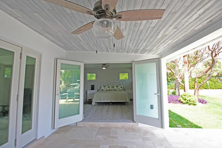 The Master Suite opens to the custom travertine patio, pool and dock