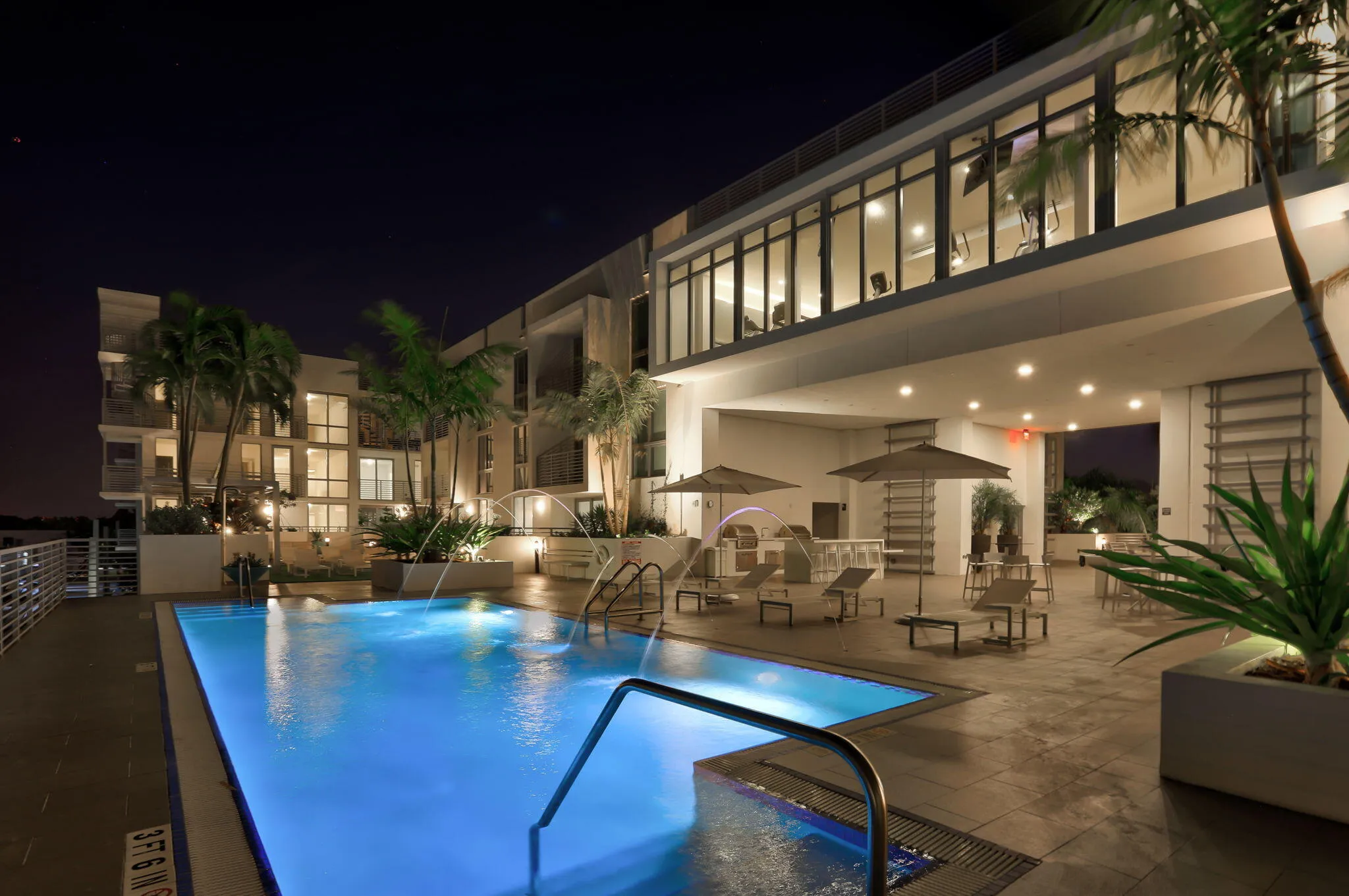 Twilight view of pool and fitness area