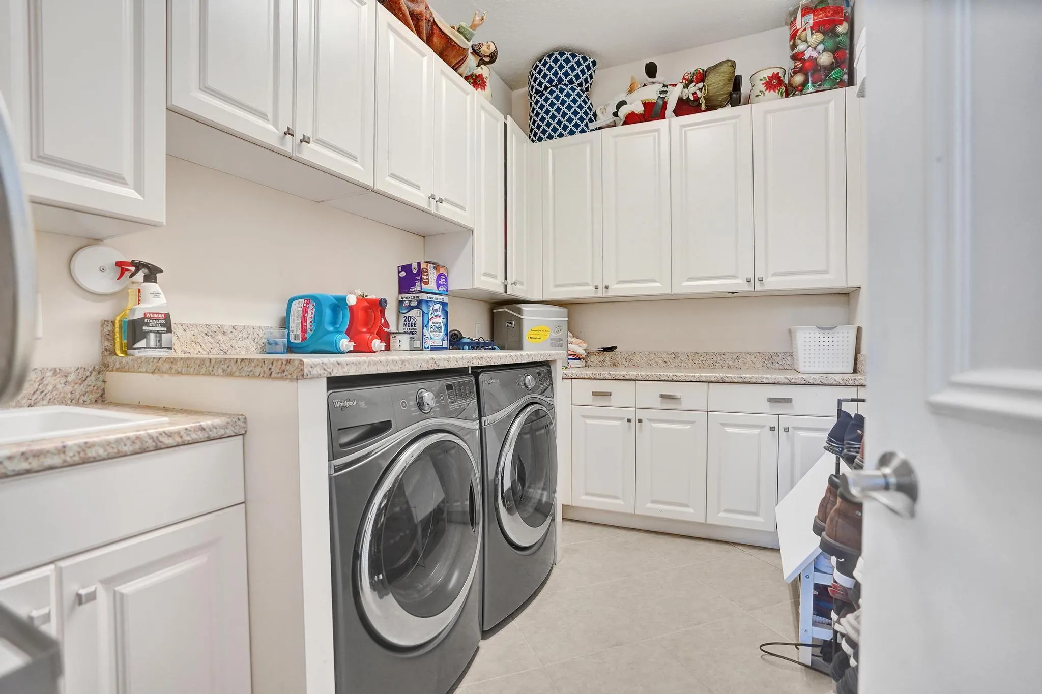 Interior Utility room with side by side washer and dryer plus wash basin. Counters and cabinets abundant. Internet Technology panel across from washer dryer. Wired and ready to have buyer install model to run tech