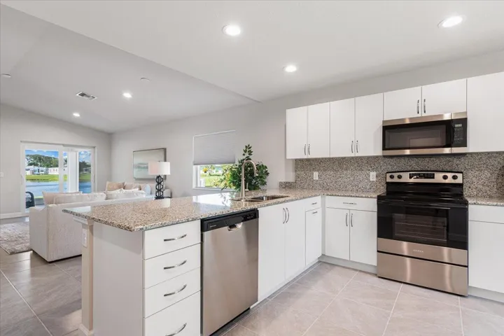 Designed for both everyday living and entertaining, this spacious kitchen offers ample counter space, generous storage, and an open layout overlooking the great room and lake beyond.