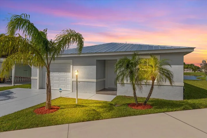 Beautifully maintained CBS home with a metal roof, fresh landscaping, and peaceful lake views.