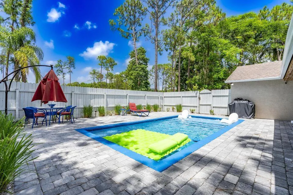 Resort-style heated saltwater pool with sundeck, covered patio, and new pavers. Perfect for entertaining, relaxing, and enjoying the outdoors.