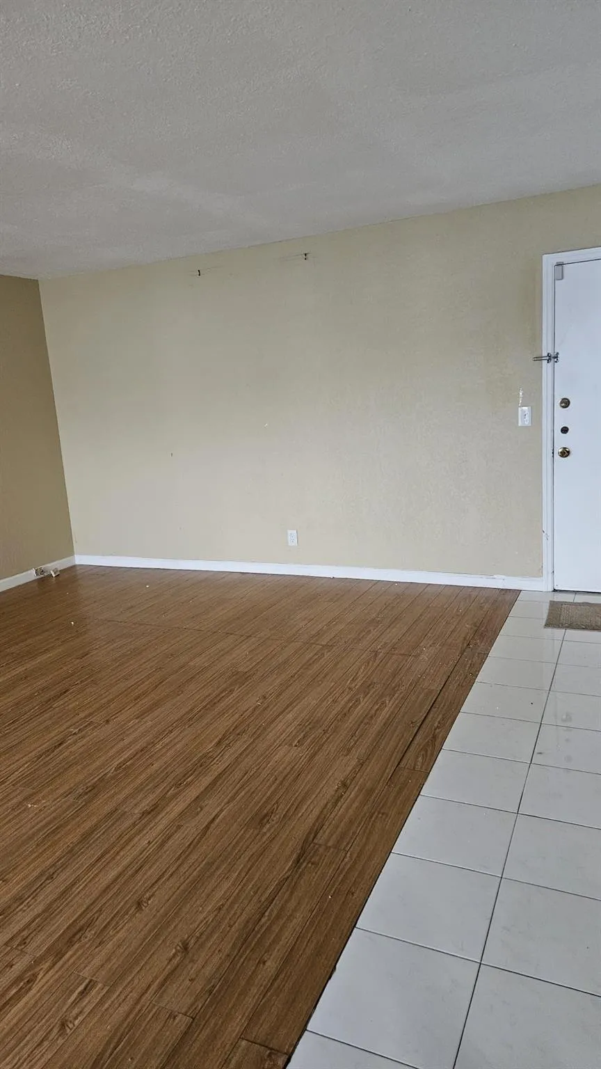 Front door and entrance to unit. Living room with laminate floors and tile