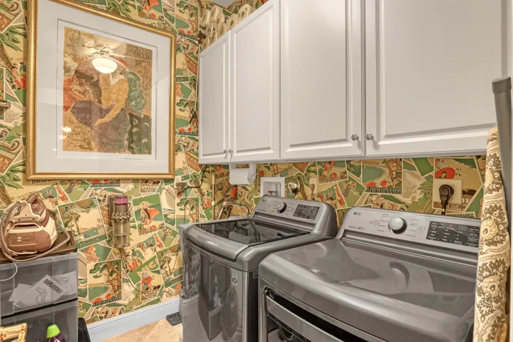 colorful wallpapered laundry room with washer dryer