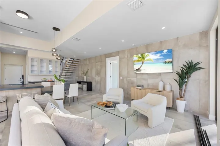 Open concept living area featuring high ceilings, recessed lighting, and a modern staircase with open risers