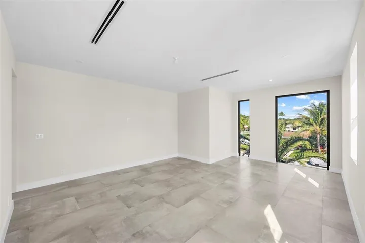 Expansive room featuring large format tile flooring, recessed lighting, and wall-mounted air vents