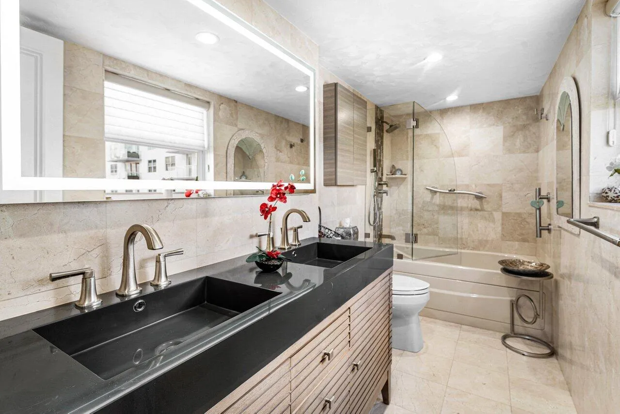 Upgraded Primary Bathroom with Dual Sinks, a Light up Mirror and a Glass Enclosed Walk in Shower and a Window
