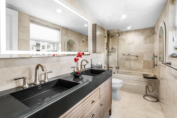 Upgraded Primary Bathroom with Dual Sinks, a Light up Mirror and a Glass Enclosed Walk in Shower and a Window