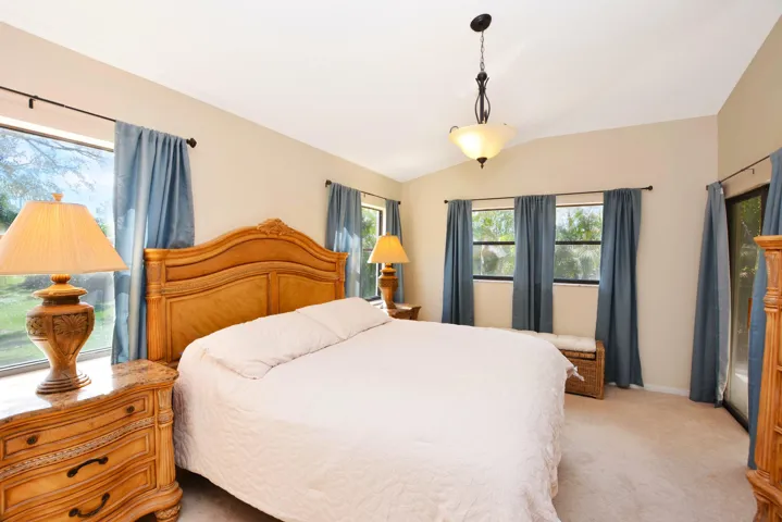 Master Bedroom with lots of windows for natural light and vaulted ceilings. Professional organizer designed walk in closet. Closet.